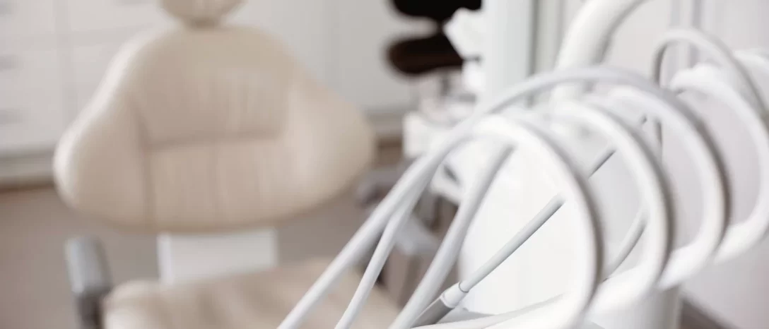Odontologiniai instrumentai prie paciento kėdės klinikos kabinete