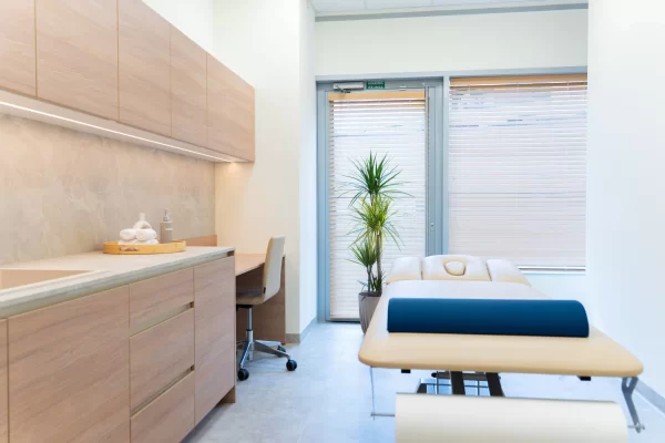 Medicinos klinikos privatūs apžiūros kambariai su užuolaidomis ir gultu