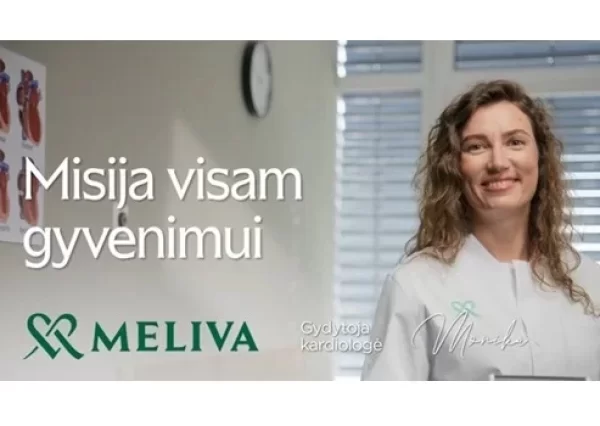 Gydytoja stovi ir žiūri į kamerą