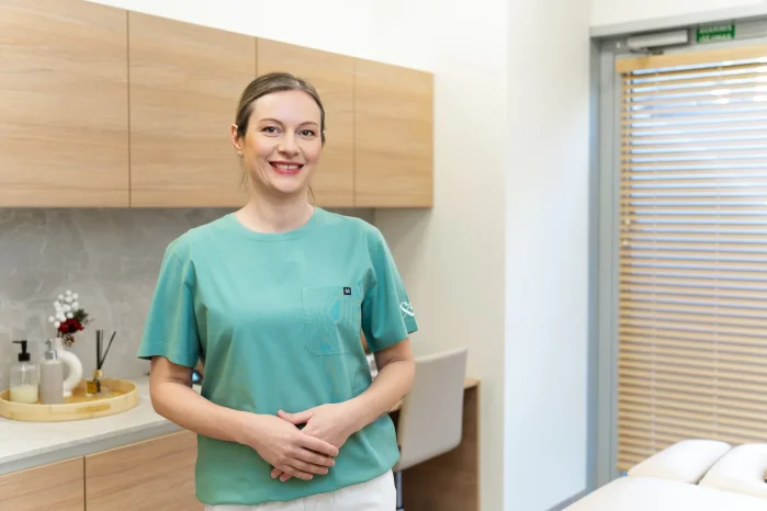 Masažuotoja stovinti kabinete reabilitacijos klinikoje