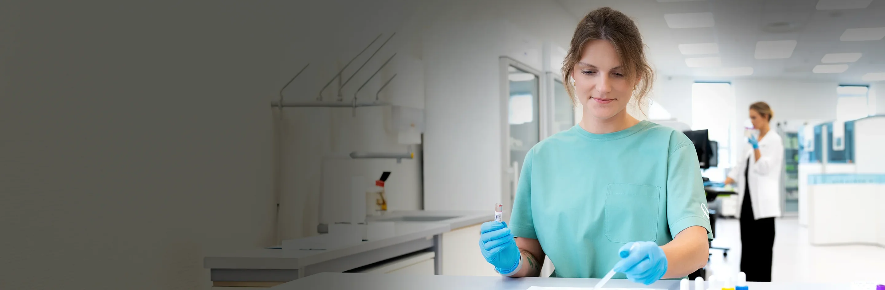 Mėlynai apsirengus mergina daranti laboratorinius tyrimus