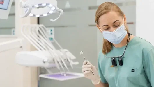 Odontologijos specialistas atlieka dantų gydymą modernioje klinikoje.
