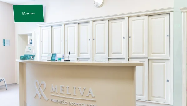 Dvi moterys apsirengusios su žalia apranga žiūri į ekraną