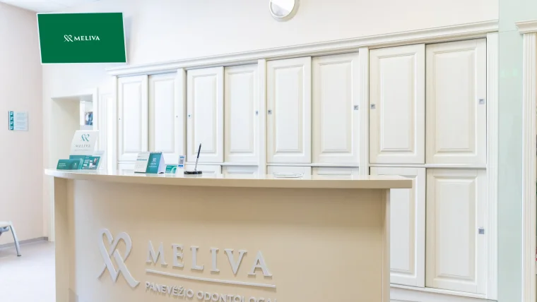 Dvi moterys apsirengusios su žalia apranga žiūri į ekraną
