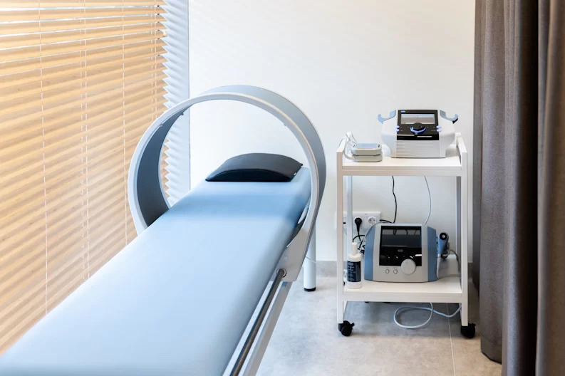 Fizioterapijos įranga su gydymo aparatu ir gultu klinikos kabinete