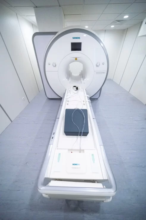 MRT aparatas iš priekio su įvažiuojančiu paciento stalu